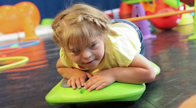 Une enfant allongée sur le ventre sur la planche de surf