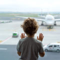 Un enfant regarde les avions par la fenêtre de l'aéroport