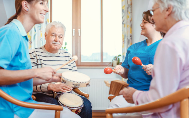 Des personnes âgées et des membres du personnel soignant jouent d'instruments de musique