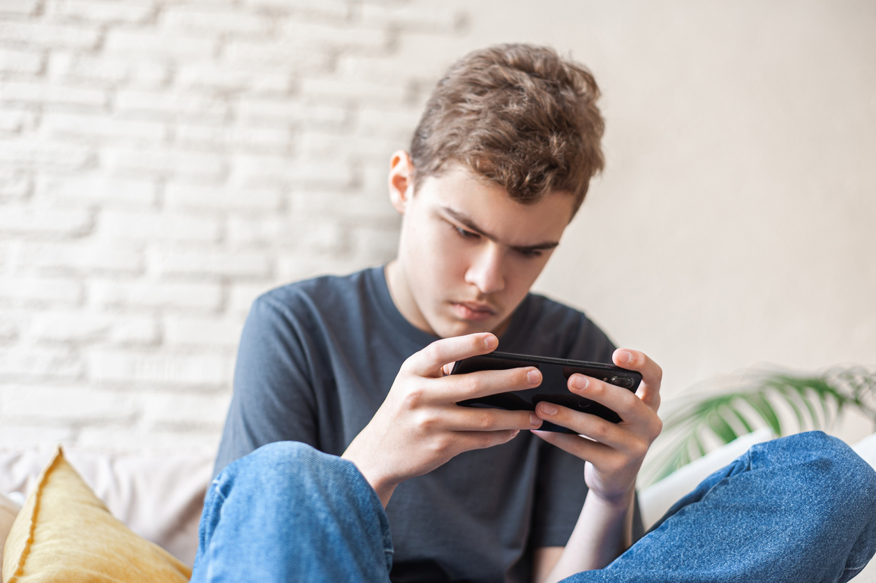 Un adolescent joue sur son smartphone