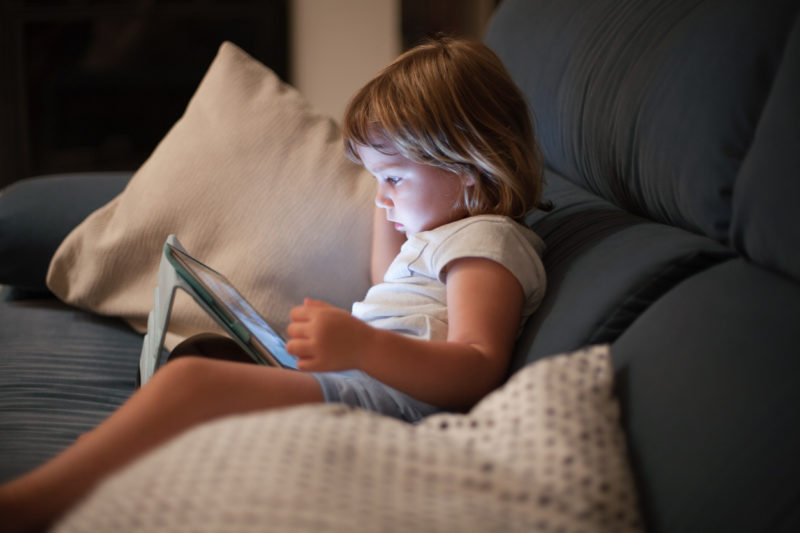 Une enfant regarde un programme sur une tablette