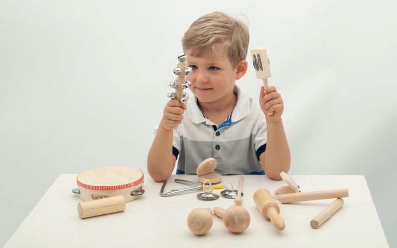 Un enfant joue avec des instruments de musique en bois