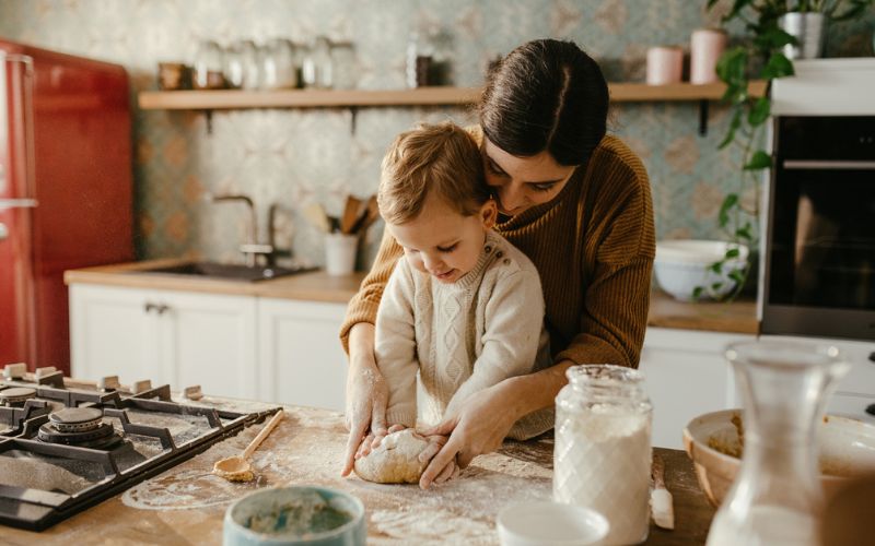 Une mère et son enfant pétrissent du pain