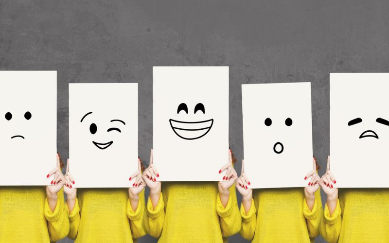 Des smileys représentés sur des cartons tenus par des personnes