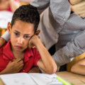 Un petit garçon pleure en classe. Son enseignante le conforte.