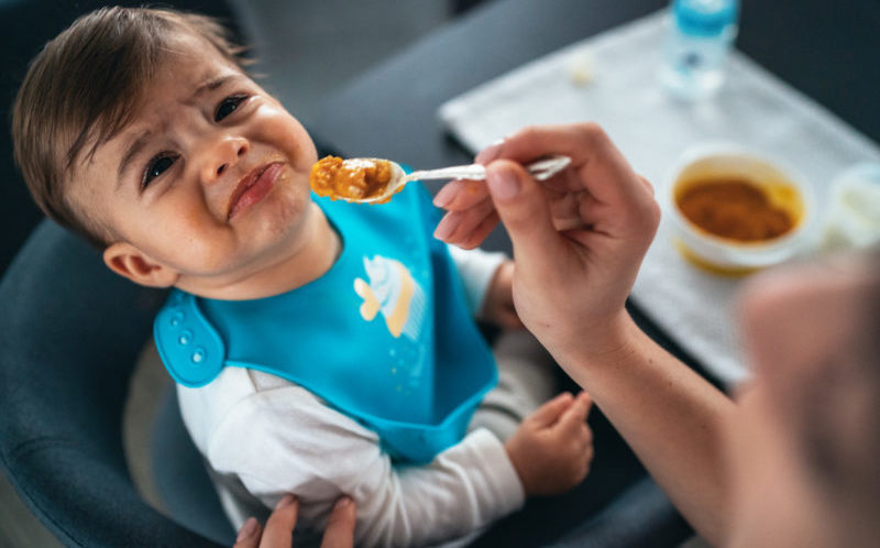 Un bébé pleure pendant son repas