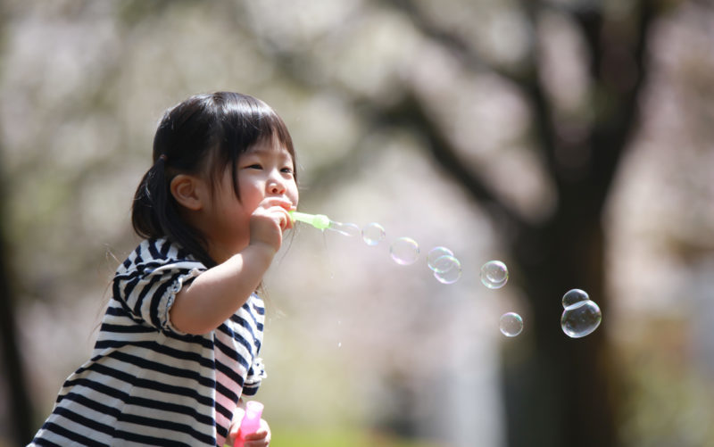 Une petite fille fait des bulles de savon