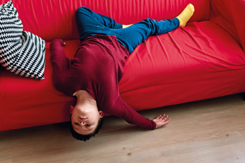 Un enfant est affalé sur un canapé