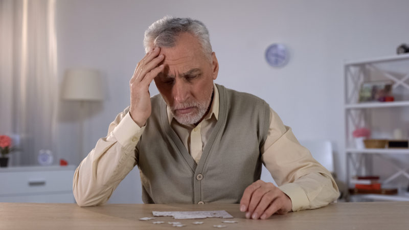 Un homme âgé se tient la tête