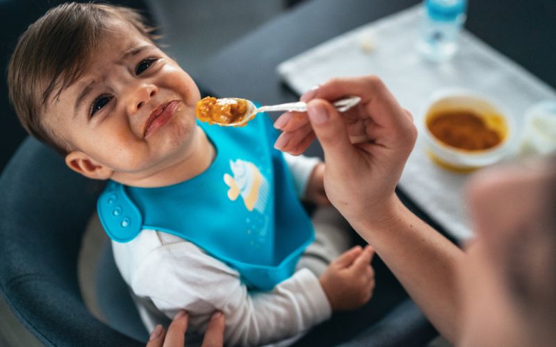 Un bébé pleure au moment du repas