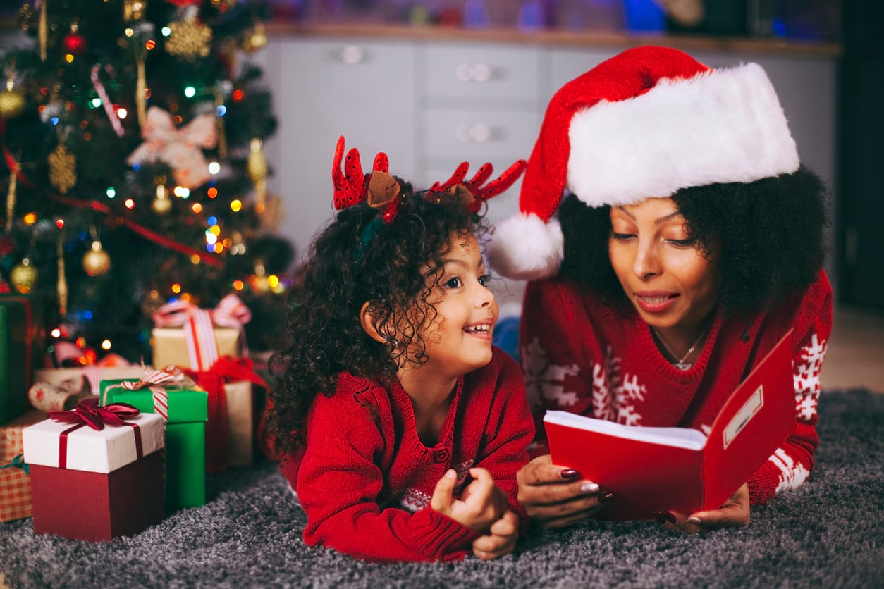 Une maman lit une histoire de Noël à son enfant