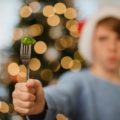 Un enfant avec un bonnet de Noël tend une fourchette