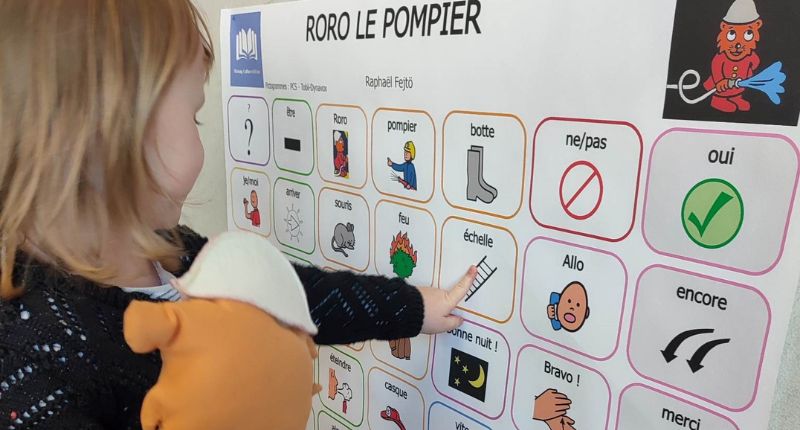 Une enfant pointe du doigt un pictogramme représentant une échelle