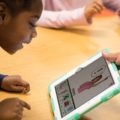 Une enfant utilise Boardmaker sur une tablette