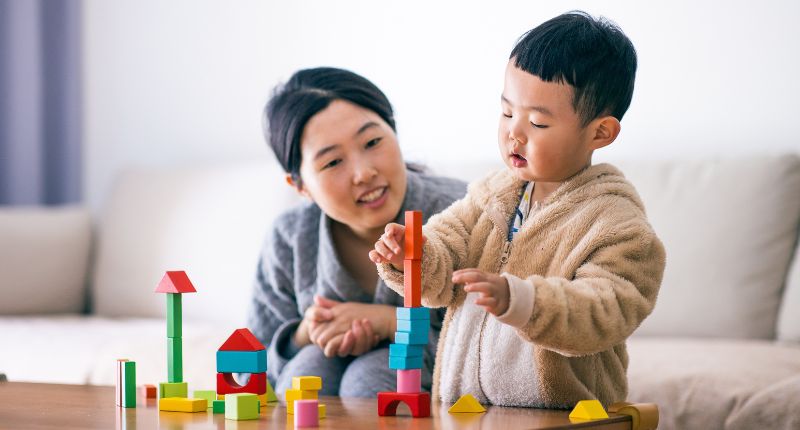 Un enfant fait un jeu de construction en bois