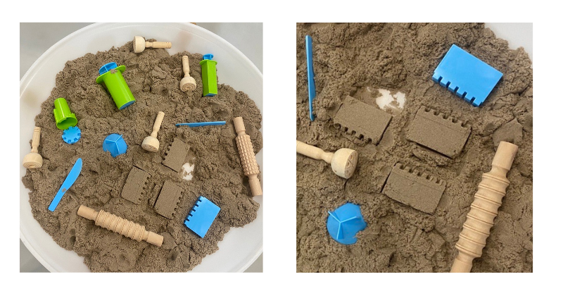 Bac d'exploration qui contient du sable kinetic et des accessoires en bois ou plastique bleu et vert pour modeler le sable.