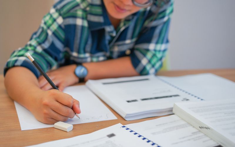 Un élève écrit sur une feuille