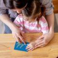 Une femme apprend à une enfant à tracer des lettres