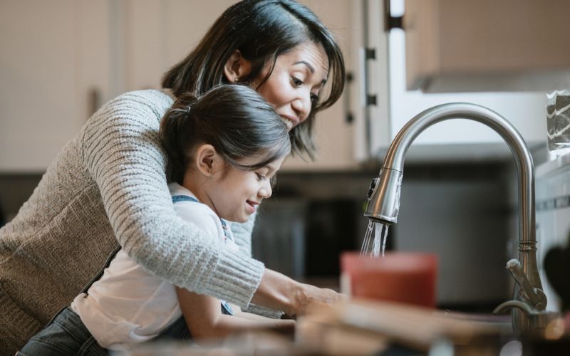 Une mère et sa fille se lavent les mains