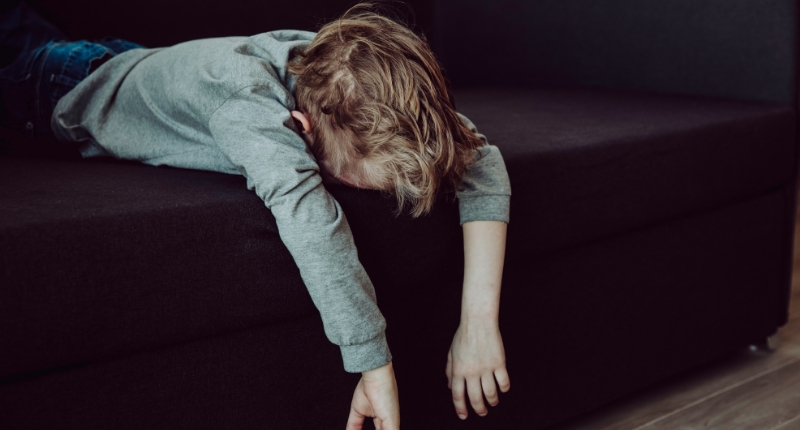 Un enfant couché sur le canapé