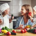 Une mère cuisine avec ses deux enfants