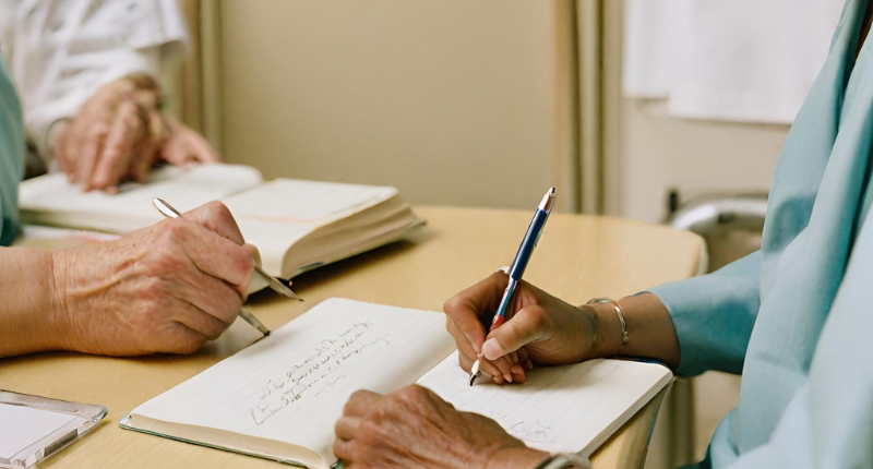 personnes écrivant sur un carnet à l'hôpital