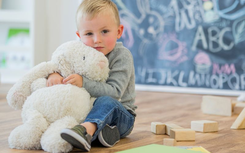 Un enfant serre une peluche dans ses bras