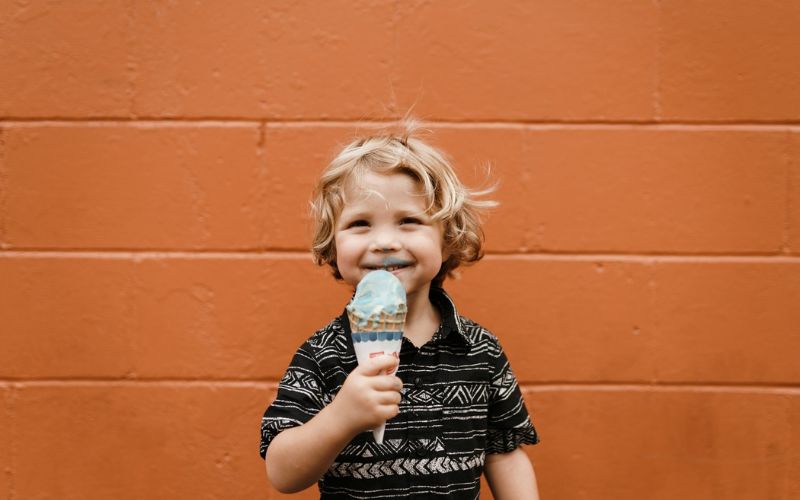 Un enfant mange une glace en souriant