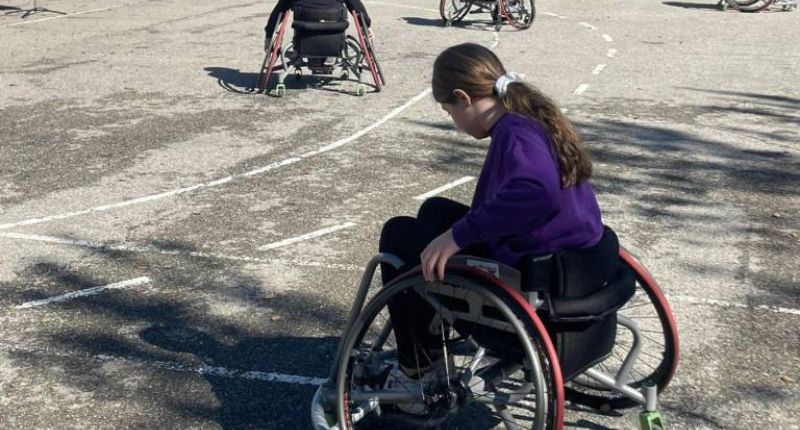 Jeune fille sur une chaise roulante spéciale pour le basket