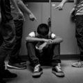 Image en noir et blanc d'un enfant pointé du doigt et moqué