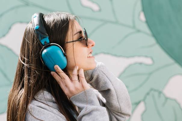 Jeune femme portant un casque antibruit en extérieur / en festival