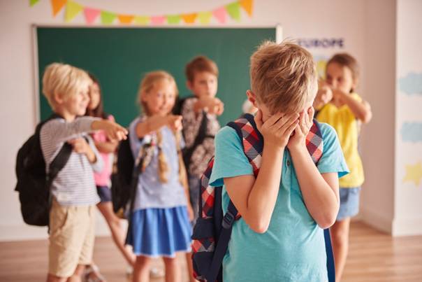 Enfant pointé du doigt et moqué par ses camarades