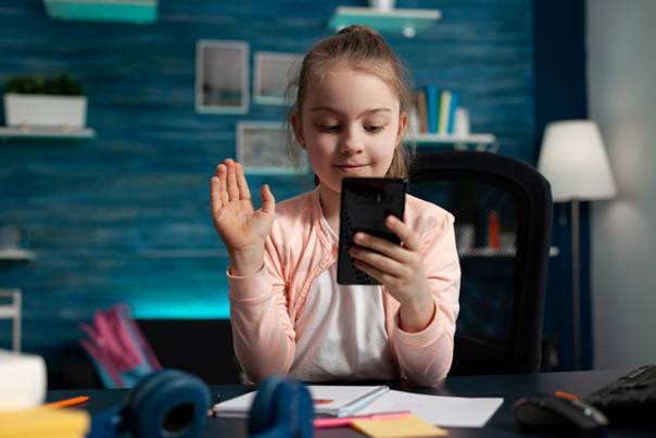 Jeune fille souriant à son smartphone dans sa chambre