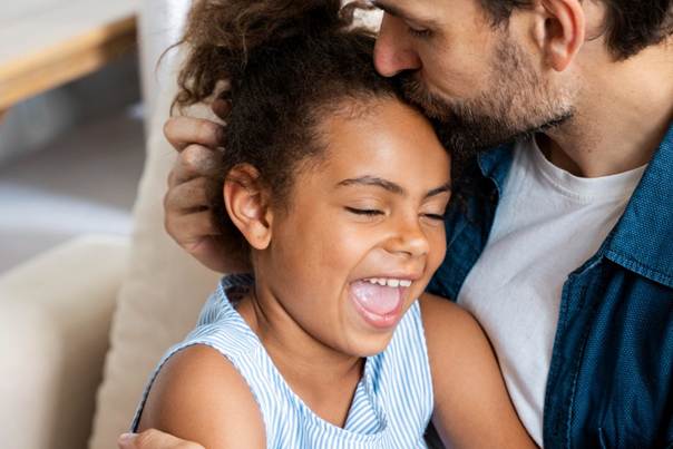 Père embrassant le front de sa fille