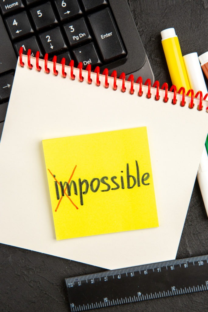 post-it avec IMPOSSIBLE écrit où le IM est barré