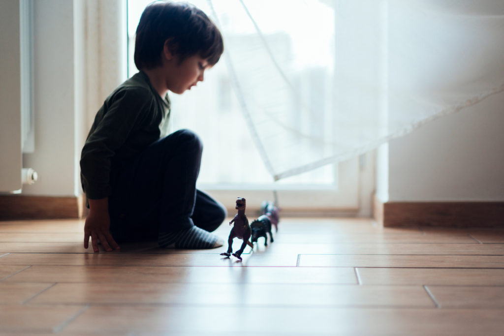Enfant jouant avec des figurines en plastique