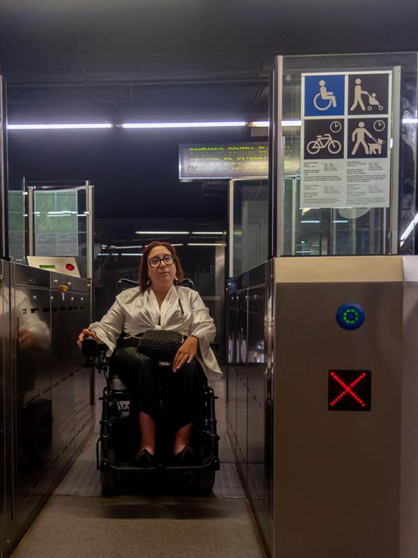 Personne en fauteuil roulant passant un portique de métro