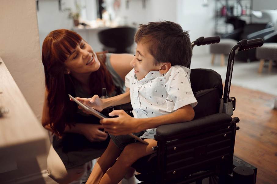 Enfant en situation de handicap dans un salon de coiffure avec une coiffeuse à ses côtés