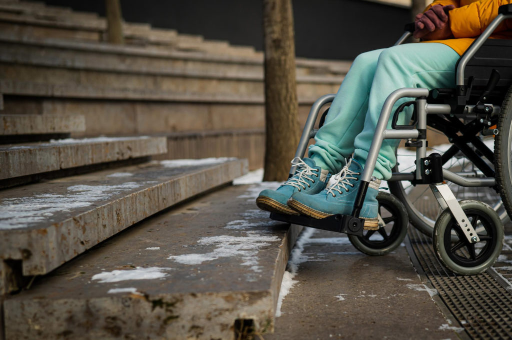Personne en situation de handicap face un escalier