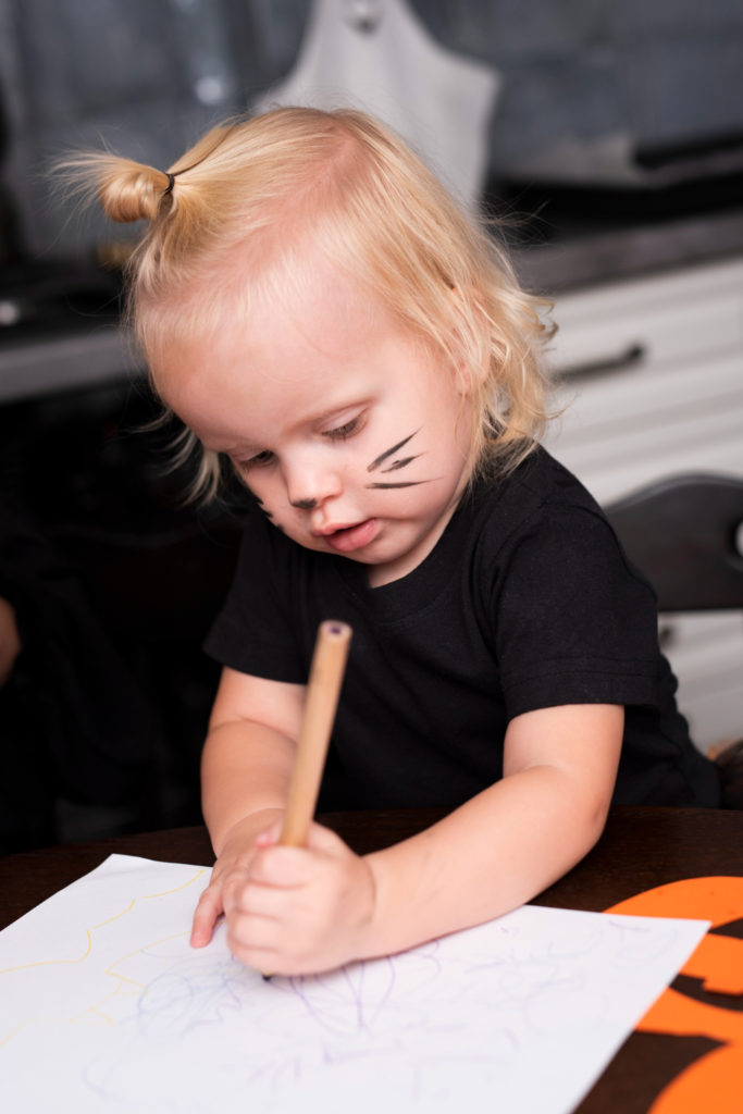 Petite fille tenant un crayon