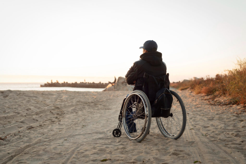 Personne en fauteuil roulant sur la plage