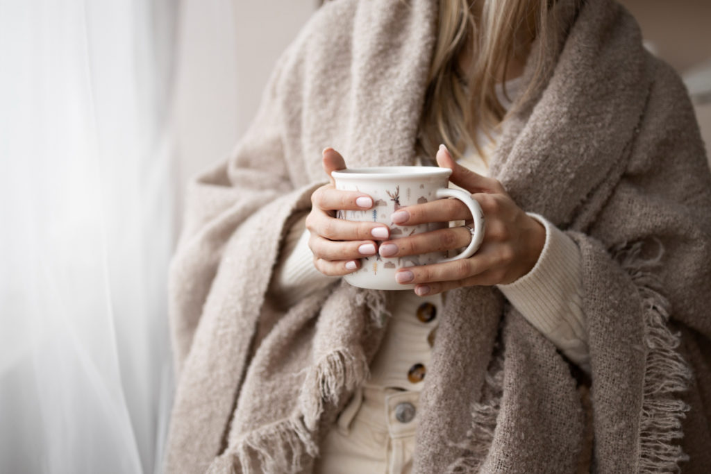 Femme avec une tasse à la main en train de coconner