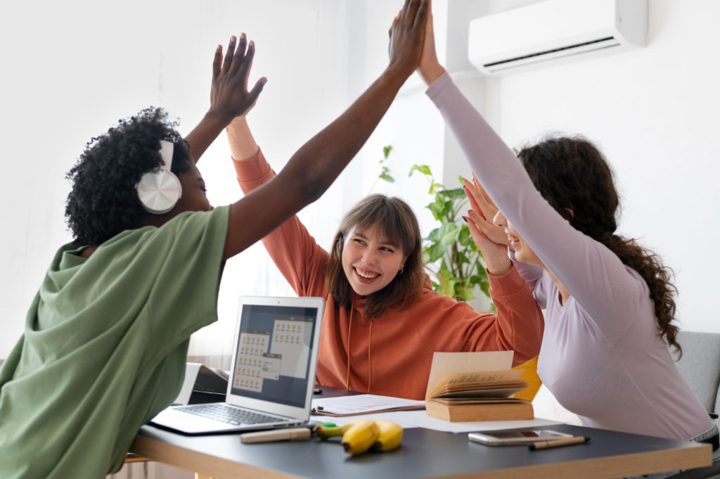 3 personnes dont une avec un casque audio au travail collaborant
