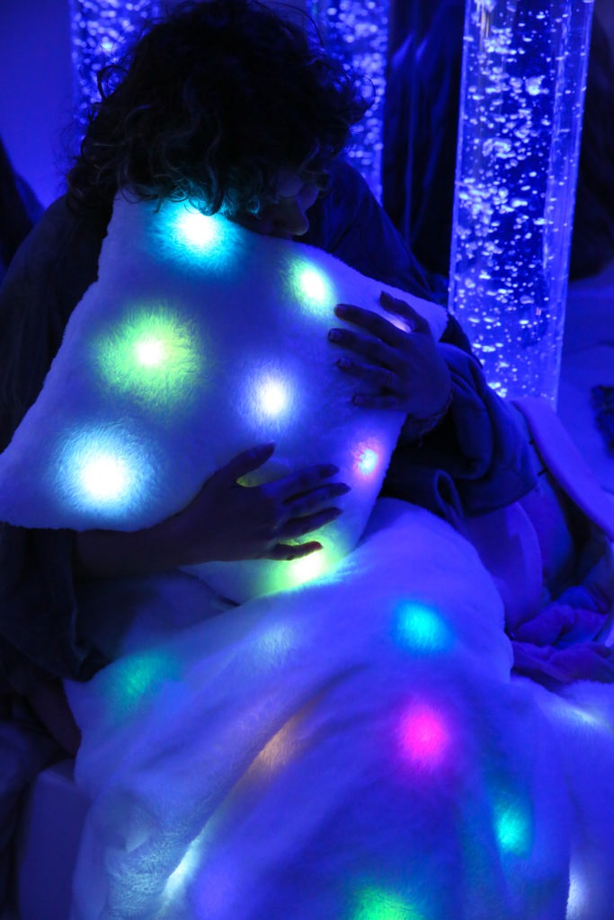 Daisy de Hop'Toys en train de cocooner dans une couverture et un coussin lumineux