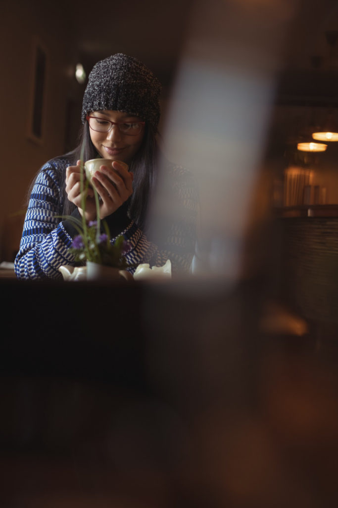 Femme avec tasse en intérieur en automne