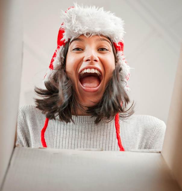 Femme excitée en ouvrant son cadeau de Noël