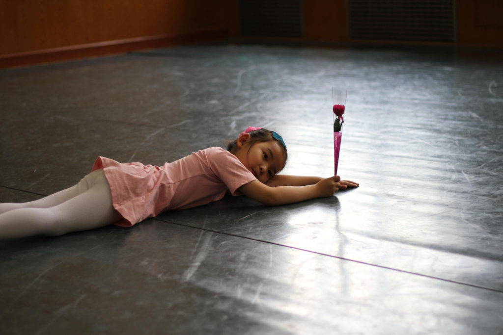 Jeune fille dansant à même le sol, allongée
